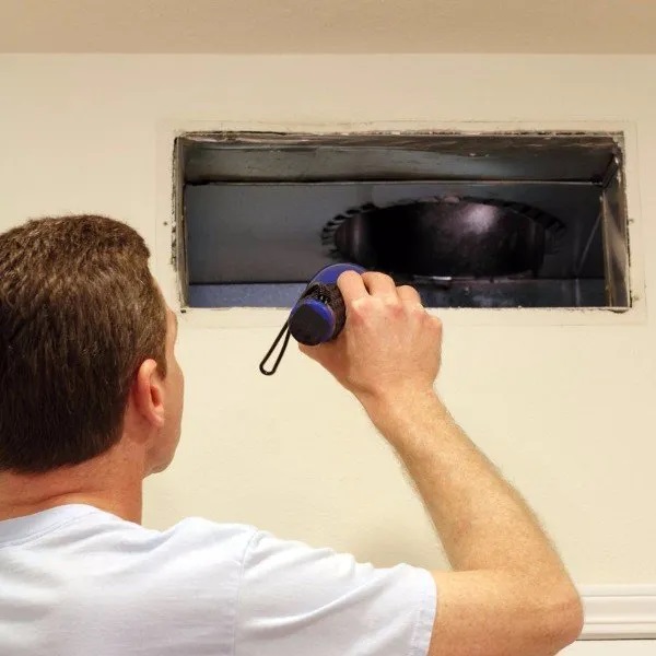 an employee cleaning the air duct systems of a home